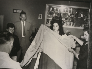 Grupo de personas observando una bandera en la que se lee la palabra "loretxorta"