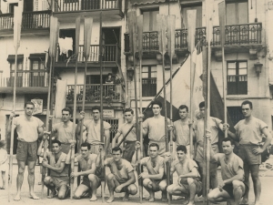 Campeones de la bandera de San Sebastián posando con sus remos y la bandera frente al ayuntamiento en la plaza de Santiago