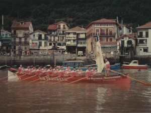 Remeros del Donibaneko, campeones de la regata de la Concha de San Sebastián, bogan con la bandera en manos del patrón