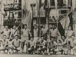 Campeones de la bandera de San Sebastián posando con sus remos y la bandera frente al ayuntamiento en la plaza de Santiago